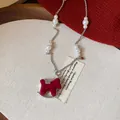 Detailed view of a red flocked rocking horse pendant on an elegant pearl necklace chain - 3# Necklace-Pearl Metal Splicing Chain / Red