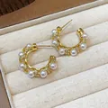 Detail view of gold-plated hoop earrings with elegant pearls and zircons - Gold