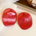 Close-up detail of red textured round resin earrings featuring a vintage translucent finish - Red