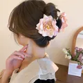 Close-up detail of a large pink rose fabric flower hair claw clip in a messy bun - Rose Hair Claw / Pink