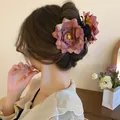 Close-up of a dusty pink rose flower hair claw clip worn in an elegant bun hairstyle - Rose Hair Claw / Maroon