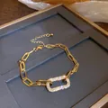 Macro view of gold-tone geometric link bracelet with shimmering pavé rectangular charm. - Bracelet / Gold