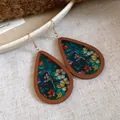 Close-up of bohemian wood teardrop earrings with colorful floral stained glass print - Style 1