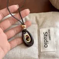 Tiger eye stone resin oval pendant necklace on studio background - Oval / Brown