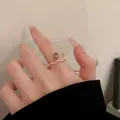 Detail shot of elegant golden wave ring with zircon and round stone ring on finger - Double Layer Wave Style (2# Ring) / Gold