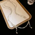 Elegant double-layered pearl necklace featuring shimmering rhinestone teardrop pendants details. - Double-Layer Beaded Necklace / White
