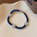 Detaillierte Makroansicht eines eleganten Blumenarmbands mit blauen und weißen Zirkonia. - Silber-Blau