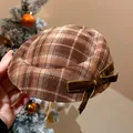Dettaglio di un elegante accessorio natalizio a quadri marroni con fiocco in velluto verde. - Stile Mini Cappello Fiocco Quadretti Caffè (6)
