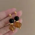 Elegante druppeloorbellen met zwarte en amberkleurige glasparels in gouden afwerking - Amber Glas Zilveren Stift Stijl / Goud-Zwart