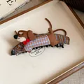 Primer plano de una pinza para el pelo de perro salchicha de tela con un lazo rojo - Clip Giratorio / Café-Azul