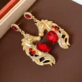 Detailed macro view of vintage gold horse earrings with vibrant red rhinestones - Pony Pendant (WE5389) / Gold-Red