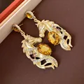 Close-up of vintage-style gold horse earrings with amber stones and clear crystals. - Pony Pendant (WE5389) / Gold-Yellow