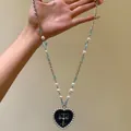 Detailed macro shot of a vintage heart pendant necklace featuring cross design and pearls - 17# Necklace-Silver-Blue