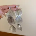Close-up of silver-toned multi-layered leaf tassel earrings with rhinestone studs - Multi-layer Hollow Petal Style