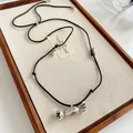 Macro view of vintage silver candy pendant on a minimalist black leather cord necklace. - Style 28-Silver Black
