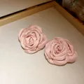 Nahaufnahme einer rosa Satinrose für ein elegantes französisches Halsschmuck-Detail - 925 Sterling Silber Ohrstecker / Rosa