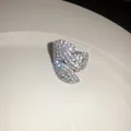 Detalle de un pendiente de flor con pedrería brillante en un plato de cerámica - Anillo abierto / Plateado
