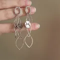 Close-up detail of fashionable silver-tone hollow-out circular tassel drop earrings - Silver Earring Post Style / Silver
