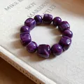 Close-up detail of purple marbled acrylic geometric beads on a stylish handmade bracelet. - Purple