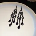 Detail of vintage black chandelier teardrop earrings with intricate hollow design - Black