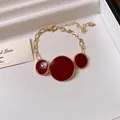 Detailed view of a vintage gold necklace with three red enamel circular pendants - Bracelet / Red