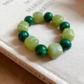Detail view of green acrylic beaded bracelet with irregular marbled geometric textures. - Green