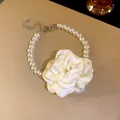 Detailansicht der weißen Stoffblume und runden Perlen an einer antiken Halskette. - Armband / Weiß