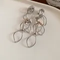 Elegant silver hollow leaf tassel earrings with polished round discs for women's fashion - Clip-on Style / Silver