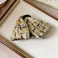 Detail view of a stylish colorful tweed plaid bow hair clip with a vintage fabric texture - Hair Claw / Brown