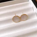 Elegant round stud earrings with white marble texture and gold beaded edges. - Stud Earrings / White