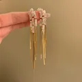 Dettaglio di eleganti orecchini lunghi a nappa in oro con pietre di zircone brillanti - Rettangolo Oro Placcato Oro Vero (6#)