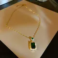 Detailed macro view of a vintage gold necklace featuring a square emerald green pendant - Emerald Pendant (HN1665) / Gold