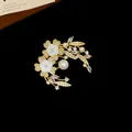 Détail macro d'une élégante broche fleur plaquée or avec zircone et perles sur velours noir - 1# Style Forme Florale