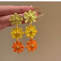Detailed macro shot of summer vacation style woven tricolor flower drop earrings - 6# Silver Needle - Green - Yellow - Orange