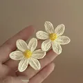 Close-up of summer style woven daisy earrings with white petals and yellow center - 10# Steel Needle White