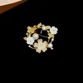 Vue détaillée d'une broche dorée ornée de fleurs, papillons, perles et zircons - 2# Style Couronne Papillon