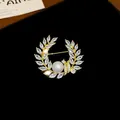 Détail macro d'une élégante broche couronne plaquée or avec zircons et perle centrale - 3# Style Forme Épi de Blé