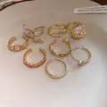 Macro view of vintage gold-plated open ring set with heart and rhinestone accents - 8-Piece Set / Gold