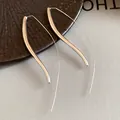 Macro detail of minimalist long curved silver earrings with a high-polished finish - Silver