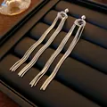 Eleganti orecchini lunghi con nappe argentate presentati su un vassoio espositore nero - Nappina Argento Placcata Oro Vero (49#)