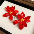 Detailed close-up view of red acrylic flower earrings with artistic yellow bead centers - Silver Needle / Red