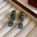 Detailed macro view of vintage gold-tone drop earrings with blue and green crystals - Ear Clip-Blue