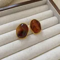 Macro detail of vintage amber oval stud earrings featuring gold twisted rope border. - Trapezoidal (8#) / Silver Needle / Gold/Brown