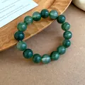 Detailed close-up of a green tie-dye beaded bracelet resting on a rustic wooden tray - Bracelet / Green