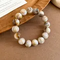 Macro view of minimalist swirled bead bracelet with unique brown and cream marble pattern - Bracelet / Brown