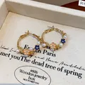 Detail view of floral hoop earrings with pearls and pink enamel on a jewelry box - Round Pearl Floral Earrings (HE29162) / Gold Pink Blue Drop Oil Flower Style