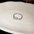 Dettaglio macro di anello aperto argentato con farfalle scintillanti in zircone - Argento