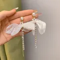 Eleganti orecchini dolci con fiocco bianco e lunga nappa di perle con dettaglio a stella - Stile Fiocco Bianco con Nappa