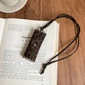 Close-up of leopard print leather pouch pendant necklace with vintage book background - Round / Dark Coffee