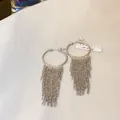 Detailed macro view of elegant silver-toned geometric fringe tassel earrings for women - Geometric Hoop Tassel Style / Silver